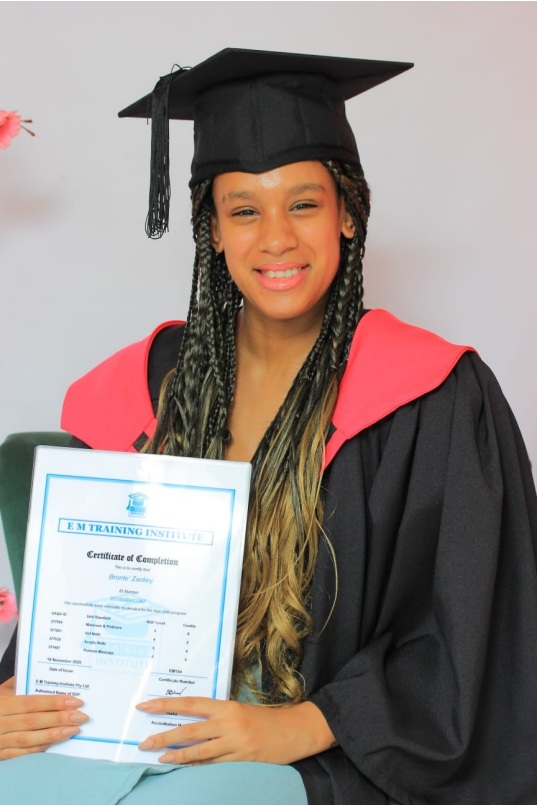 Graduate pictured with her E M Training Institute certificate